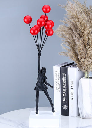Girl holding red balloons statuette 