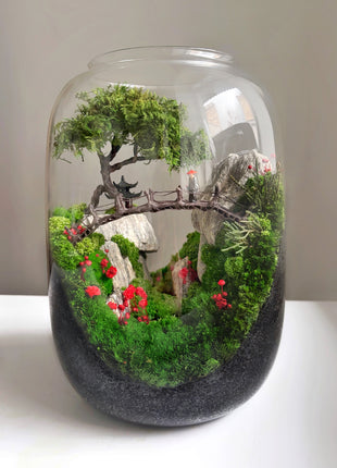 Decorative moss terrarium with bonsai tree rocks and red floral accents