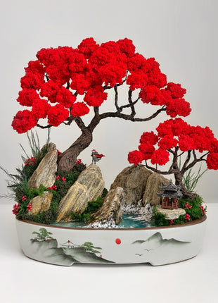 Red bonsai landscape with red trees, rocks and blue river in ceramic tray